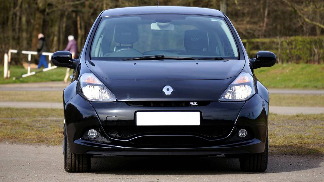 Stunning black Renault Clio RS parked with green trees in the background, capturing the essence of a modern hot hatch.